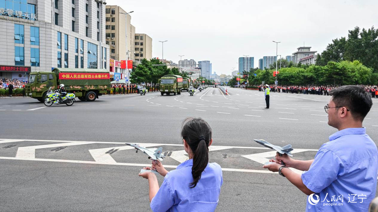 航空工業(yè)沈飛的青年技術(shù)人員拿著受閱戰(zhàn)機的模型迎接烈士遺骸。航空工業(yè)沈飛供圖