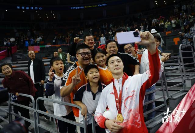 11月12日，十五運會男籃成年組決賽，廣東隊獲得冠軍后，胡明軒與球迷們合影留念。張由瓊 攝