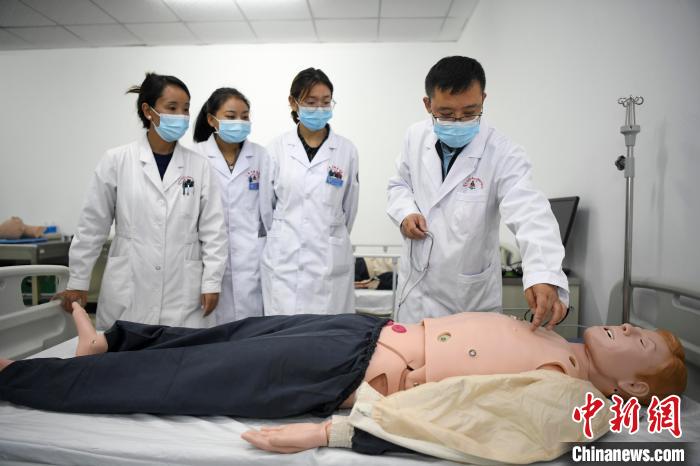 湖南中醫(yī)藥大學第一附屬醫(yī)院腦病科援藏醫(yī)生高曉峰(右一)為學生們進行體格檢查教學。　楊華峰 攝