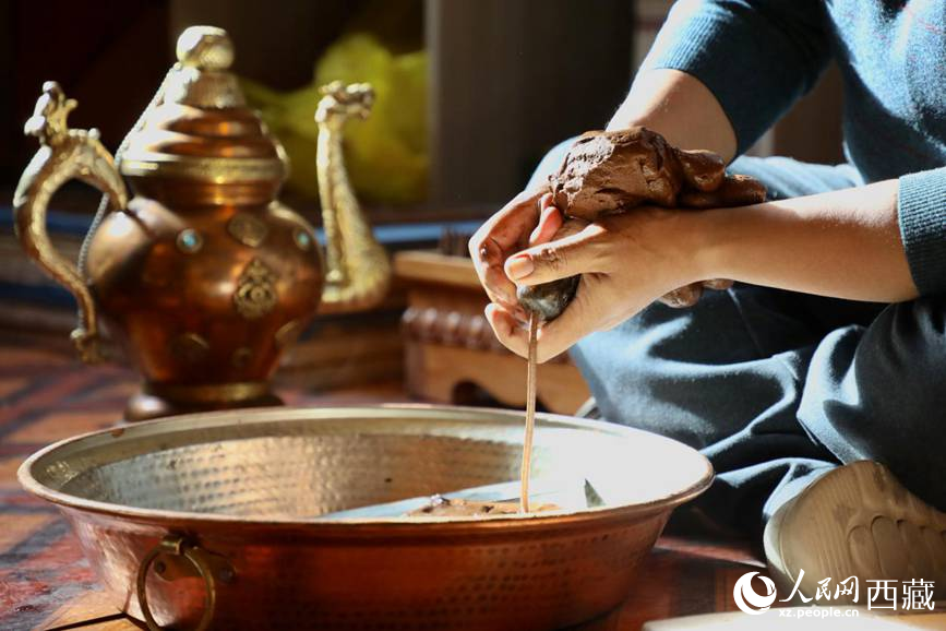 牛角鉆孔，將木泥擠出。人民網(wǎng)記者 次仁羅布攝