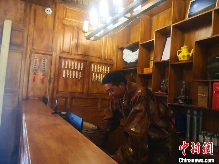 圖為桑杰才讓用電腦處理財務?！∈缝o靜 攝