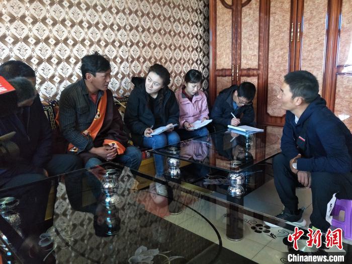 圖為調(diào)查組工作人員正在入戶調(diào)查。　祁增蓓 攝