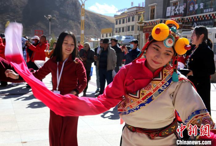 圖為中外記者向當(dāng)?shù)孛癖妼W(xué)習(xí)民族歌舞文化?！?zhí)砀?攝