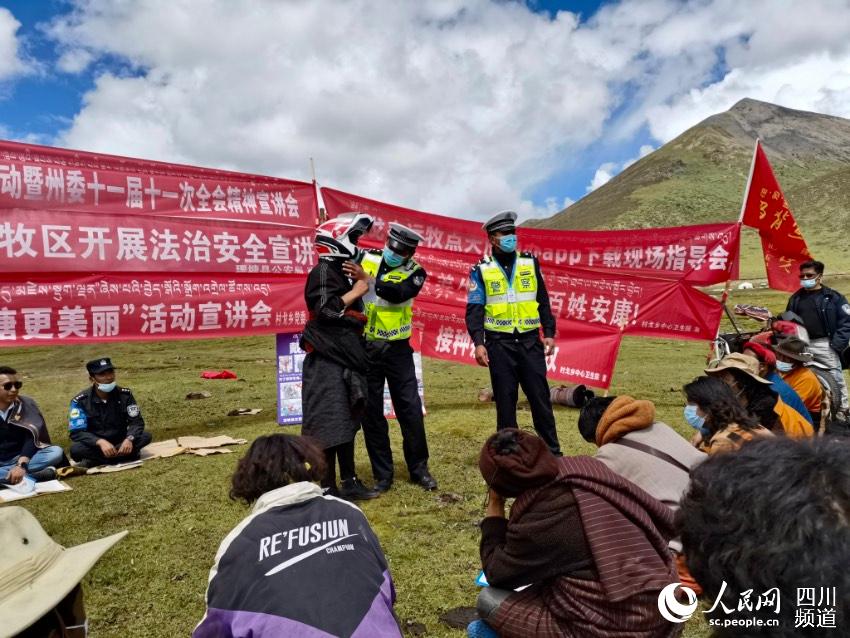 給牧民講如何佩戴安全頭盔。巴登攝