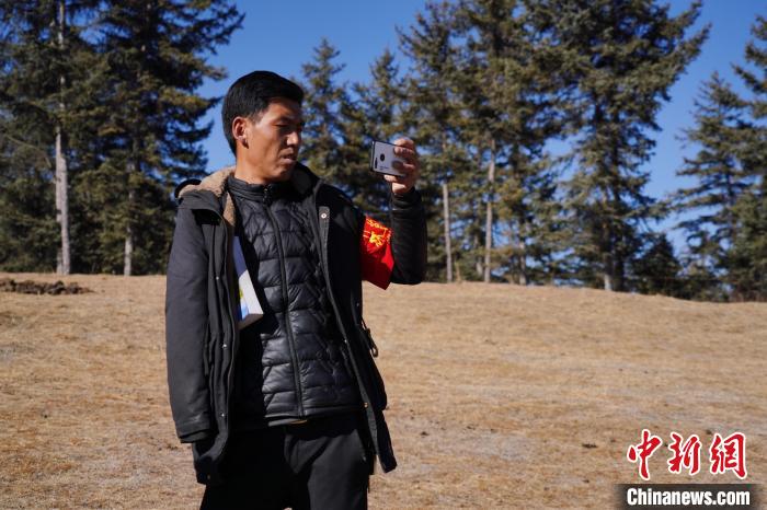 圖為桑杰加進(jìn)行巡查并拍照記錄?！●R銘言 攝