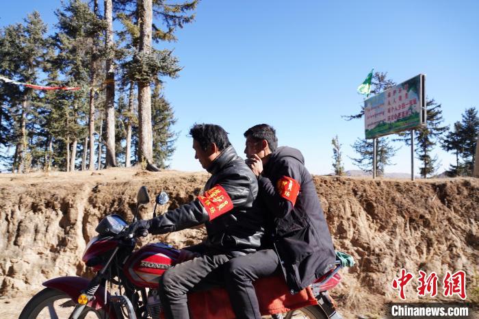 圖為同事騎摩托車載著桑杰加(后)前往林場(chǎng)?！●R銘言 攝