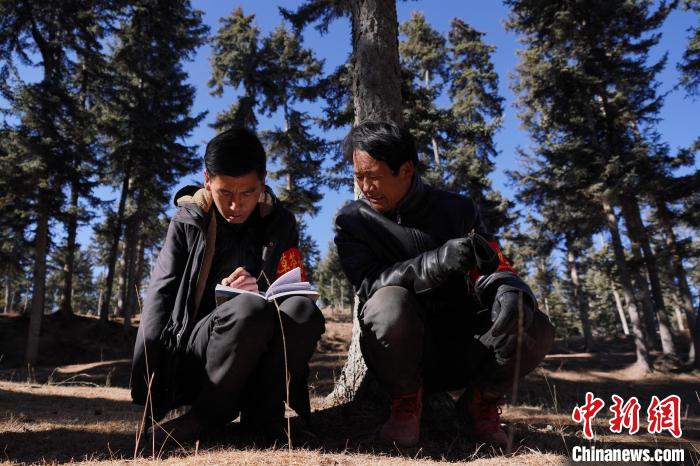 圖為桑杰加(左)和同事記錄巡查結(jié)果?！●R銘言 攝