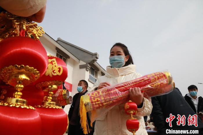 27日，蘭州新區(qū)為舟曲避險搬遷移民送“春節(jié)包”，楊周馬草前往領取，紅色寓意來年的日子紅紅火火?！∥航ㄜ?攝