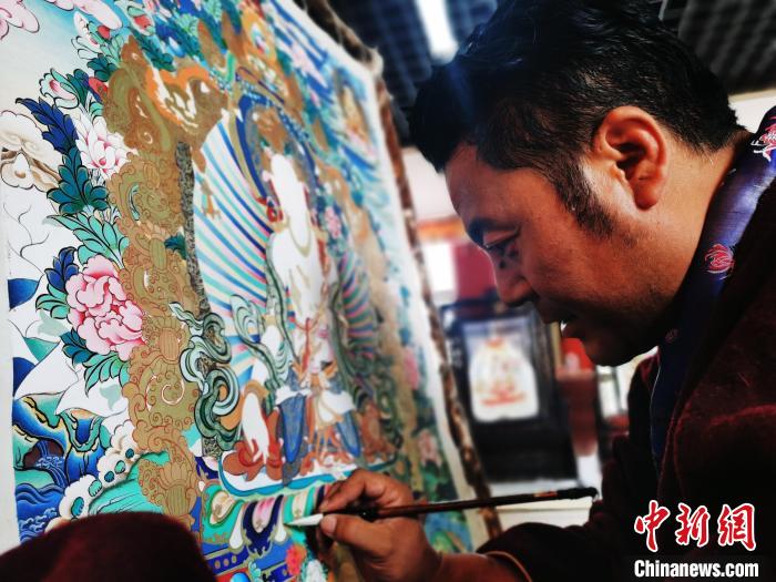 圖為久美尖措創(chuàng)作唐卡?！?zhí)砀?攝