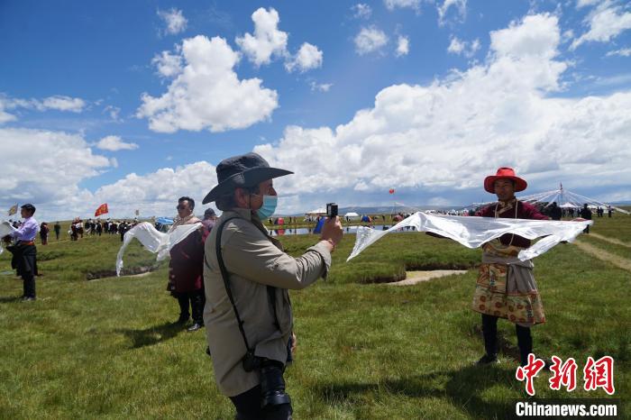 圖為一名外籍?dāng)z影師記錄當(dāng)?shù)夭刈鍤g迎儀式?！●R銘言 攝