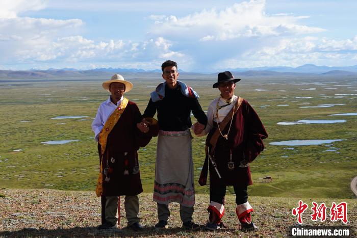 圖為一名留學(xué)生身穿自己國家的服飾和藏族民眾合影留念?！●R銘言 攝