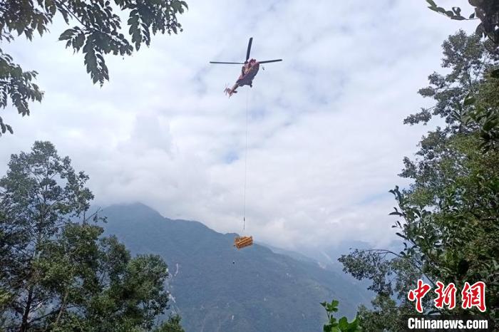 直升機起飛將搶修塔材運往海拔1950米的110千伏唐下線29號塔位?！⌒鞈c明 攝