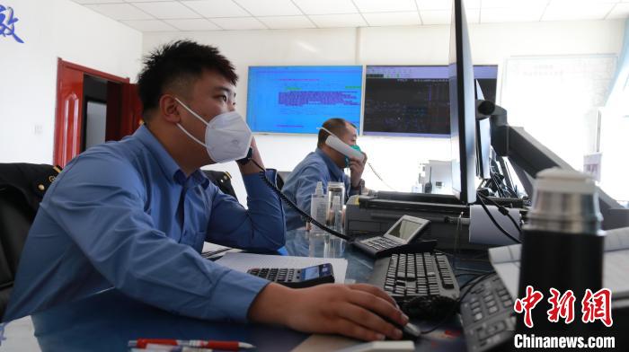 圖為貨運(yùn)調(diào)度人員與外勤工作人員聯(lián)系掌握車(chē)輛裝載情況。　李生燕 攝