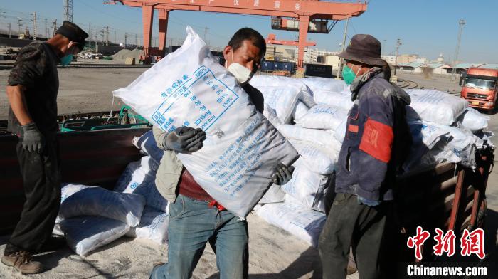 圖為裝卸人員將食鹽從汽車(chē)倒裝到火車(chē)上?！±钌?攝