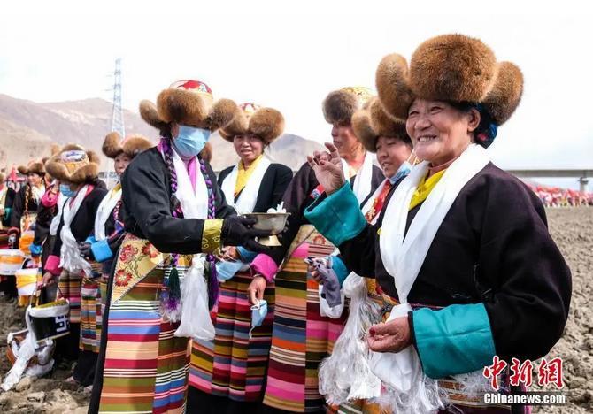 資料圖：西藏自治區(qū)拉薩市曲水縣才納鄉(xiāng)協(xié)榮村參加春耕儀式的村民互敬青稞酒。按照傳統(tǒng)，當(dāng)?shù)卮迕裆碇?jié)日盛裝，舉行隆重的儀式，祈福一年的豐收。<a target='_blank' ><p  align=