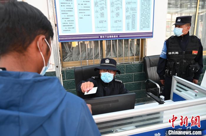 圖為移民管理警察登記完身份信息后將證件歸還給行人。　趙朗 攝