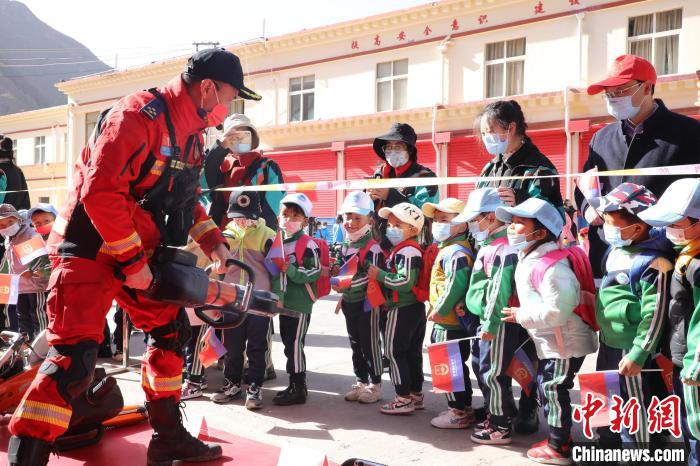 圖為消防指戰(zhàn)員為學生講解、演示先進救援裝備?！≮w琳 攝