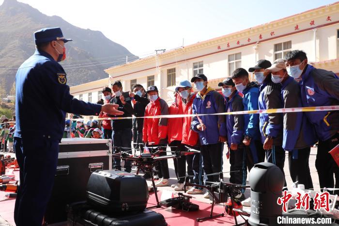 圖為消防指戰(zhàn)員為學生講解、演示先進救援裝備?！≮w琳 攝