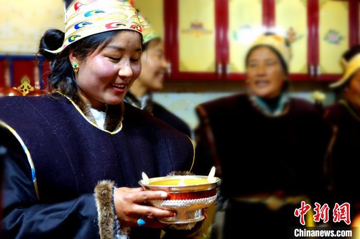 圖為藏族姑娘向客人敬酒?！∪轿木?攝