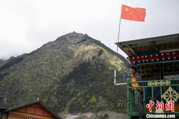 村民站在樓房上觀望?！钊A峰 攝