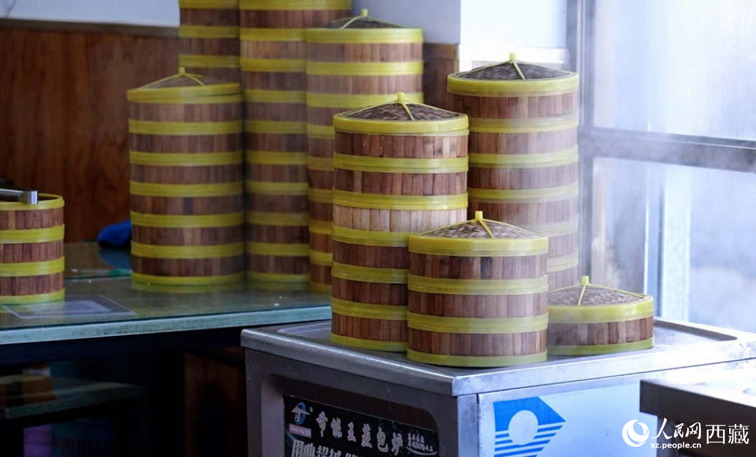 電蒸箱上擺滿了多屜熱氣騰騰的包子。人民網(wǎng) 次仁羅布攝