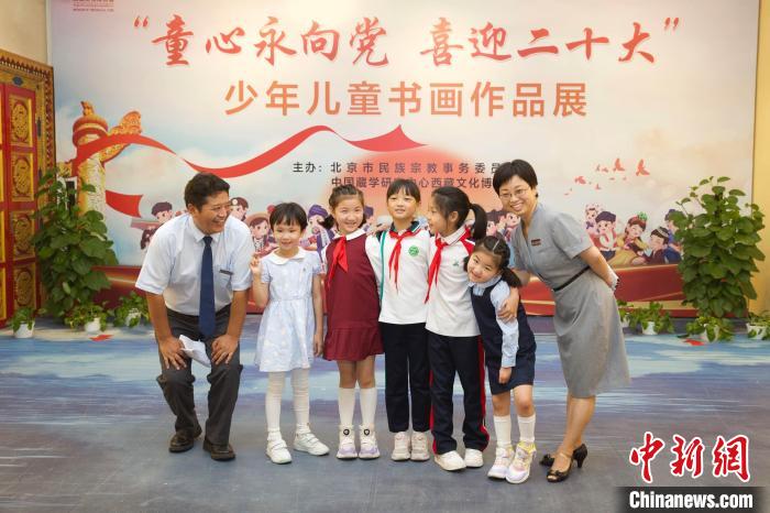 圖為與會嘉賓與入選畫作的“小作者”們在展覽上合影?！≈袊貙W(xué)研究中心供圖