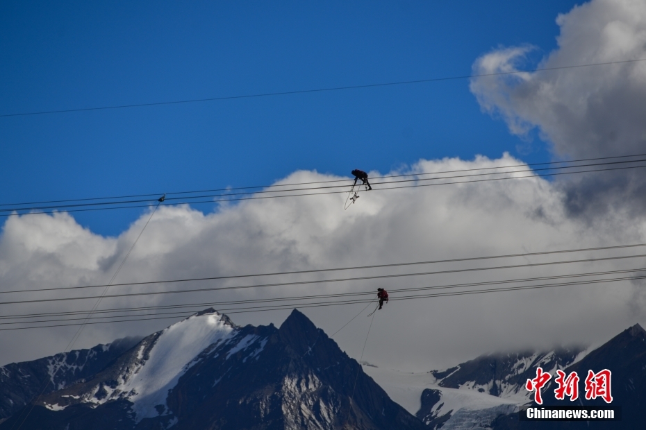 資料圖為2020年6月23日，西藏阿里聯(lián)網(wǎng)工程施工人員在日喀則希夏邦馬雪山附近進(jìn)行走線作業(yè)，安裝絕緣設(shè)備。 <a target='_blank' href='/'><p  align=