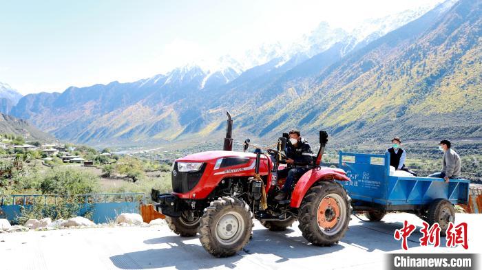 圖為工作人員將把加工完成的糌粑運(yùn)送至村民手中?！〖卫杩h融媒體中心供圖