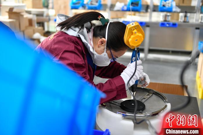 圖為工人正在組裝炊具?！∝暩聛硭?攝