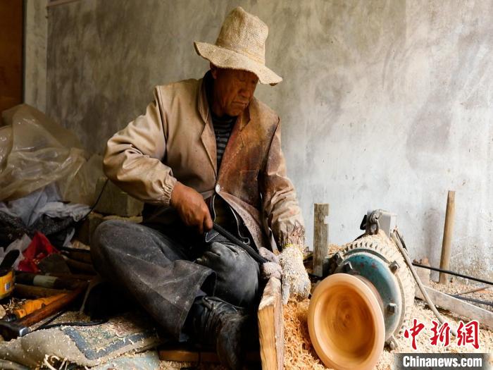 圖為手工藝人正在制作木碗?！?鄧海平 攝