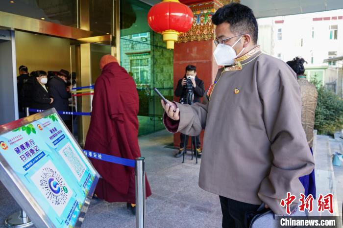 圖為政協(xié)委員掃場(chǎng)所碼進(jìn)入會(huì)場(chǎng)?！〗w波 攝