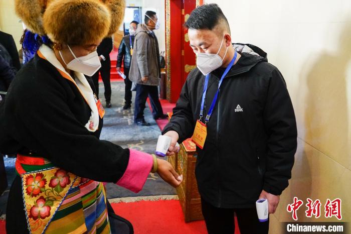 政協(xié)委員測(cè)體溫后入場(chǎng)?！〗w波 攝