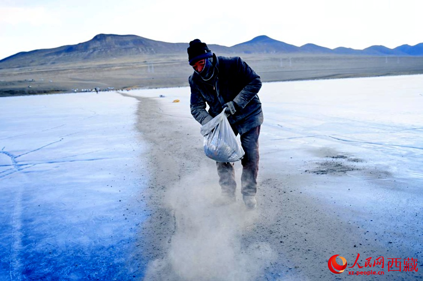 牧民在冰面上撒灰鋪成通道。人民網(wǎng) 李海霞攝