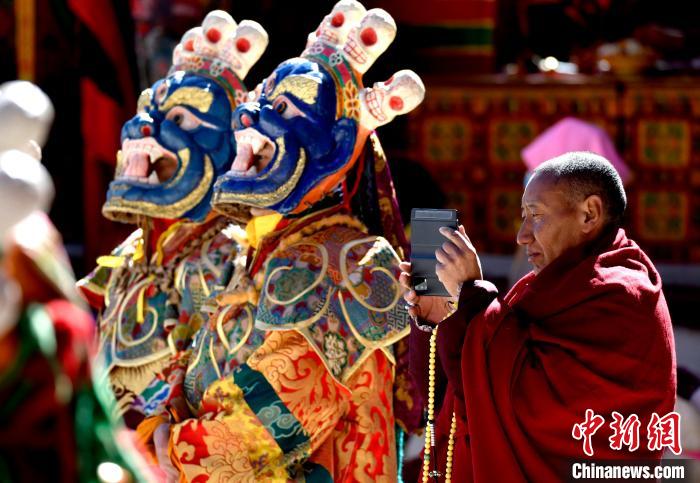 2月19日，正在拍攝跳神活動(dòng)的僧人?！±盍?攝