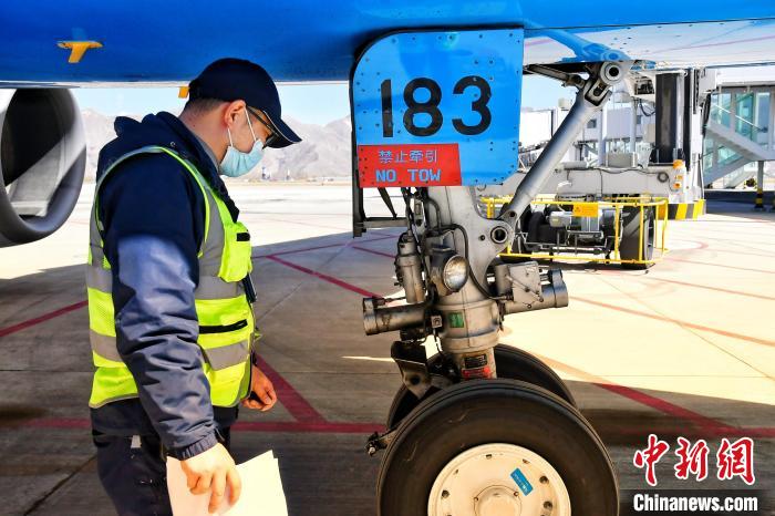 圖為機(jī)場(chǎng)工作人員進(jìn)行相關(guān)檢查。　周航 攝