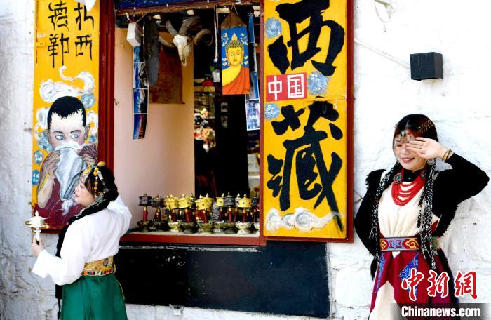 4月17日，游客身著藏式元素服裝在拉薩八廓街拍照留念?！±盍?攝
