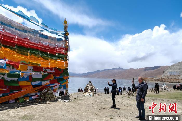 進藏參訪嘉賓在羊湖畔拍攝經幡。　江飛波 攝