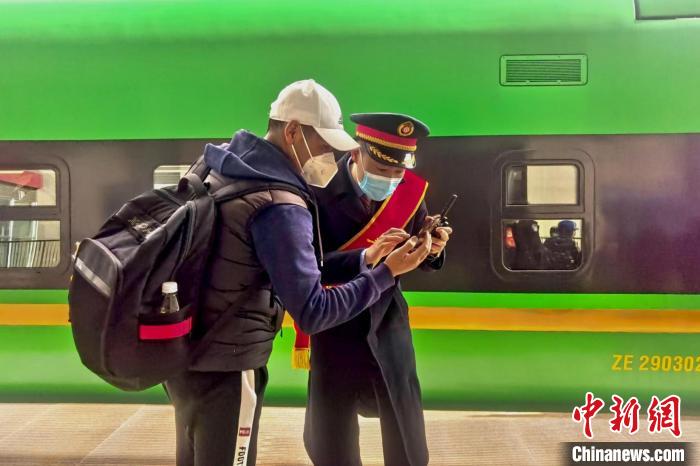 圖為日喀則火車站工作人員服務(wù)乘客?！《飞降?攝