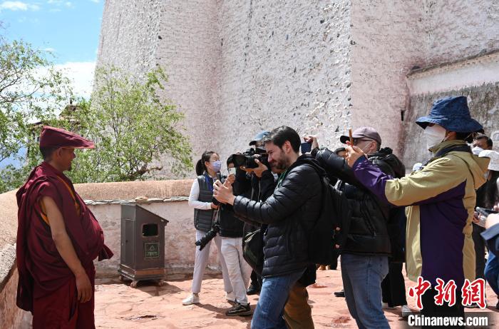 圖為中外媒體拍攝朝拜布達(dá)拉宮的僧人?！≮w朗 攝