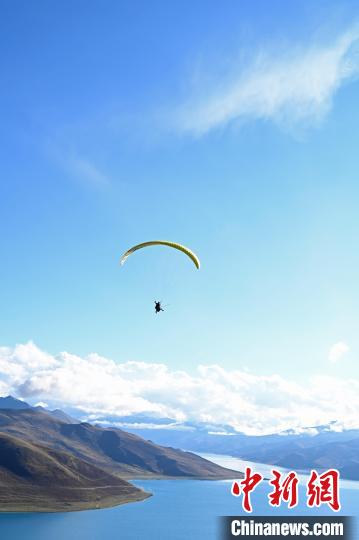 圖為在羊卓雍錯(cuò)，游客體驗(yàn)高空滑翔。　趙朗 攝