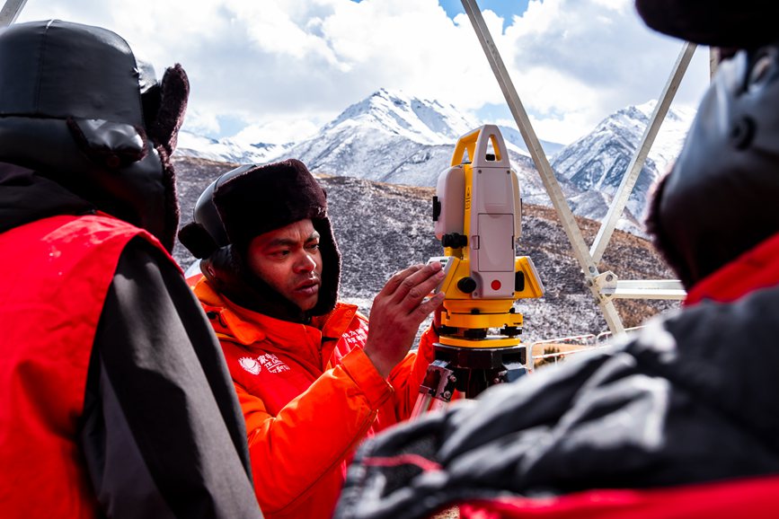 2023年11月30日，西藏自治區(qū)那曲市索縣榮布至丁青縣巴達35千伏線路工程負(fù)責(zé)人黃小洪（左二）現(xiàn)場開展線路弧測量教學(xué)。趙清鵬攝