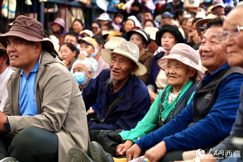 當(dāng)?shù)厝罕姾陀慰陀^看藏戲演出。