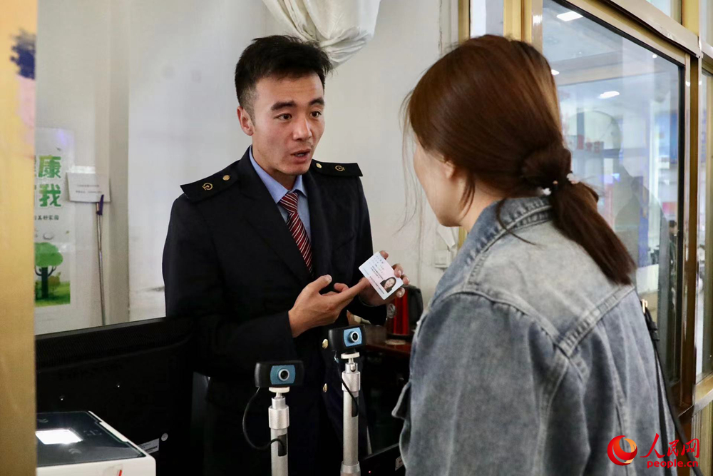 車站工作人員向旅客解答疑問。人民網(wǎng)記者 次仁羅布攝