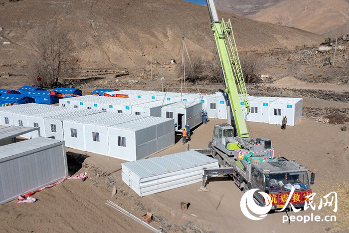 1月9日，在日喀則市定日縣長所鄉(xiāng)古榮村安置點，救援人員和施工人員合力抓緊搭建移動板房，確保受災(zāi)群眾溫暖過冬。人民網(wǎng)記者 翁奇羽攝